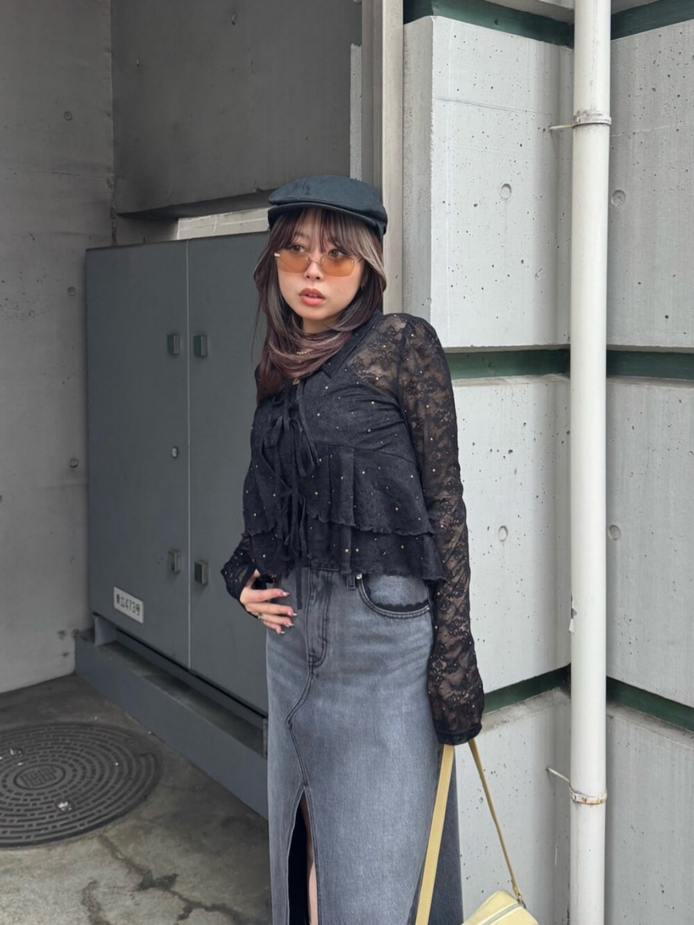 イエロー系のハンドバッグ、ブラック系のシャツ/ブラウス、ブラック系のデニムスカートを着用したレディースの春コーディネートの4枚目の写真