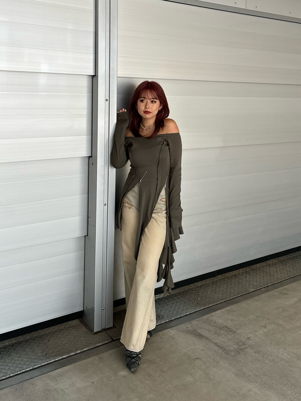 グリーン系のワンピース、ベージュ系のデニムパンツ、グリーン系のサンダルを着用したレディースの冬コーディネートの2枚目の写真