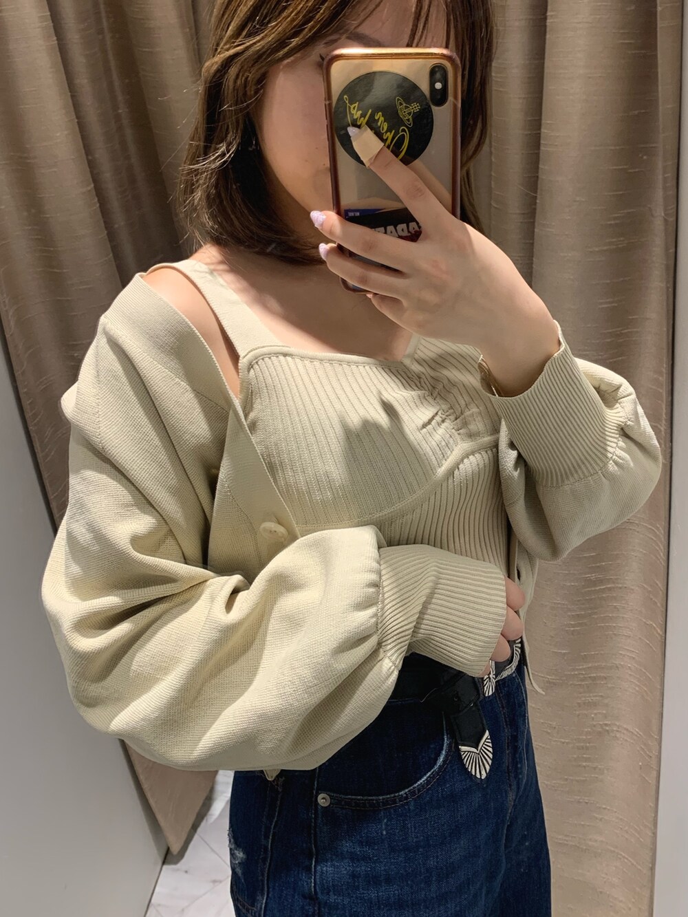 ブルー系のデニムパンツ、ホワイト系のカーディガン/ボレロ、ホワイト系のブーツを着用したレディースの冬コーディネートの3枚目の写真