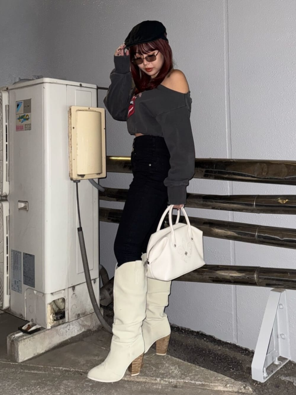 ホワイト系のボストンバッグ、ホワイト系のブーツ、ブラック系のスウェットを着用したレディースの冬コーディネートの2枚目の写真