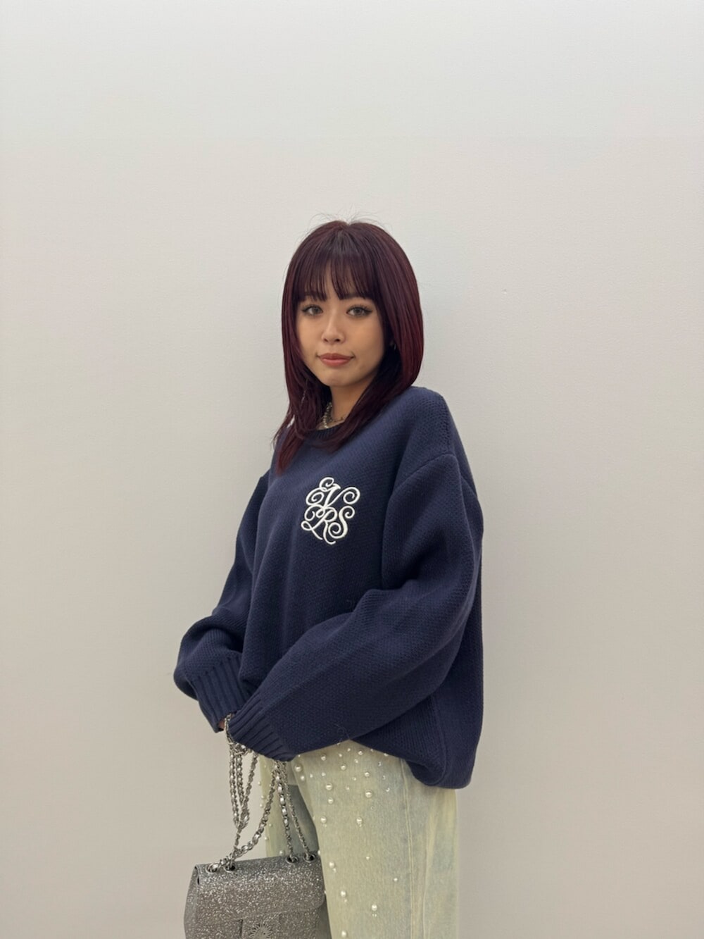 ブラック系のブーツ、ブルー系のニット/セーター、ブルー系のデニムパンツを着用したレディースの冬コーディネートの4枚目の写真