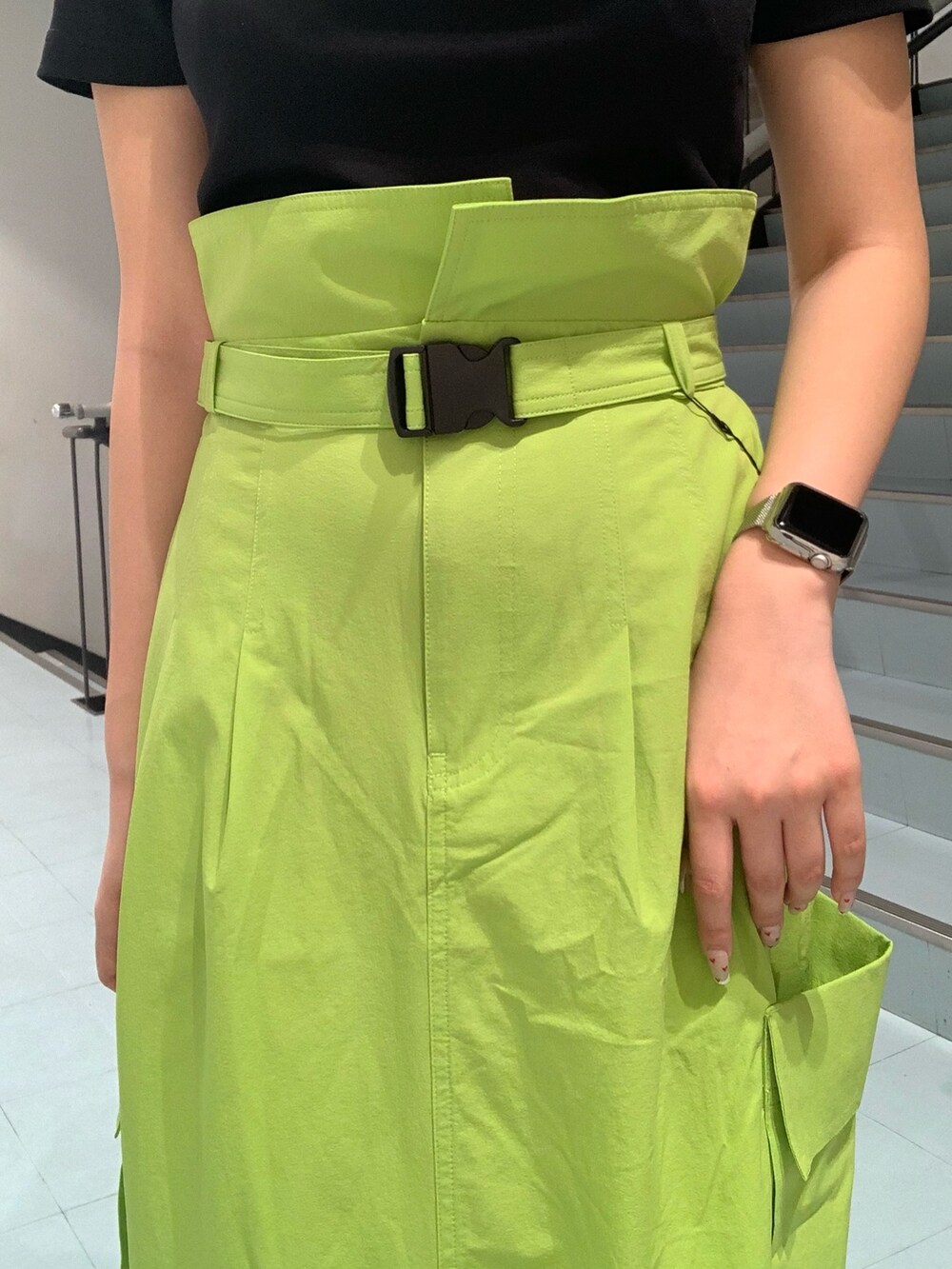 ブラック系のTシャツ/カットソー、グリーン系のスカート、ブラック系のスニーカーを着用したレディースの春コーディネートの4枚目の写真