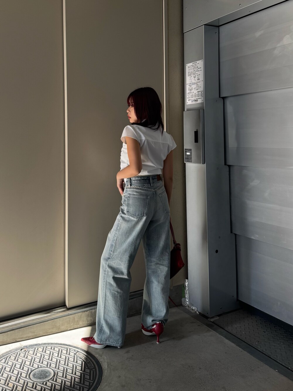 ホワイト系のシャツ/ブラウス、ブルー系のデニムパンツ、レッド系のショルダーバッグを着用したレディースの春コーディネートの3枚目の写真