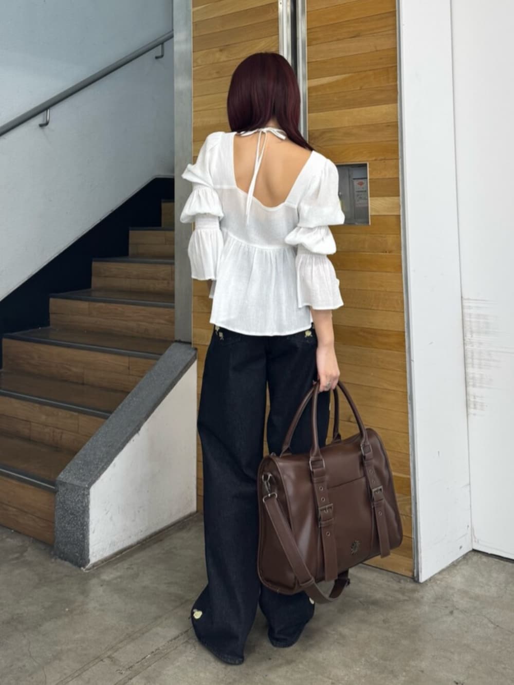 ブラウン系のサンダル、ブラック系のデニムパンツ、ホワイト系のシャツ/ブラウスを着用したレディースの冬コーディネートの3枚目の写真