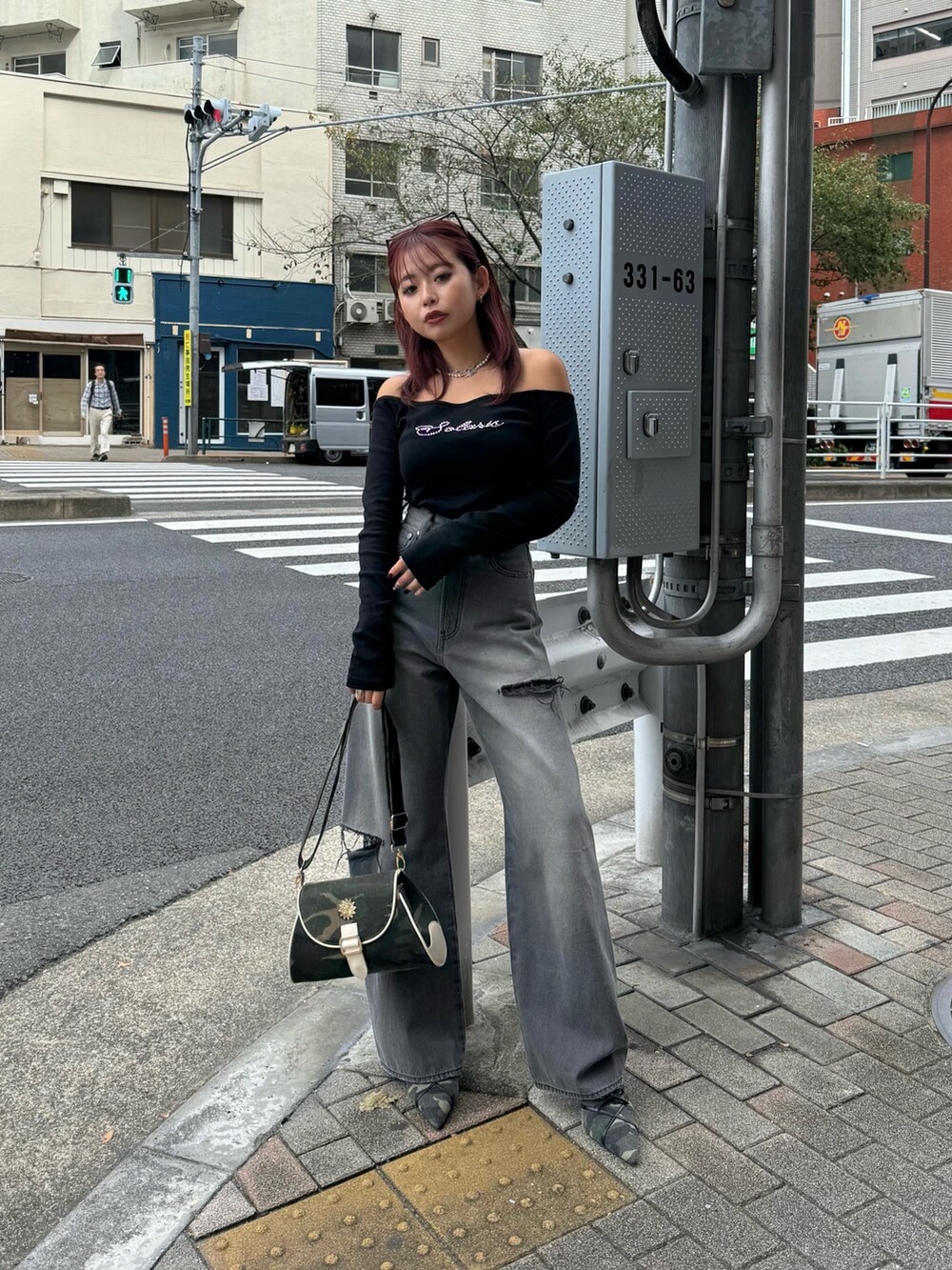 ブラック系のTシャツ/カットソー、グリーン系のショルダーバッグ、ブラック系のデニムパンツを着用したレディースの秋コーディネートの2枚目の写真