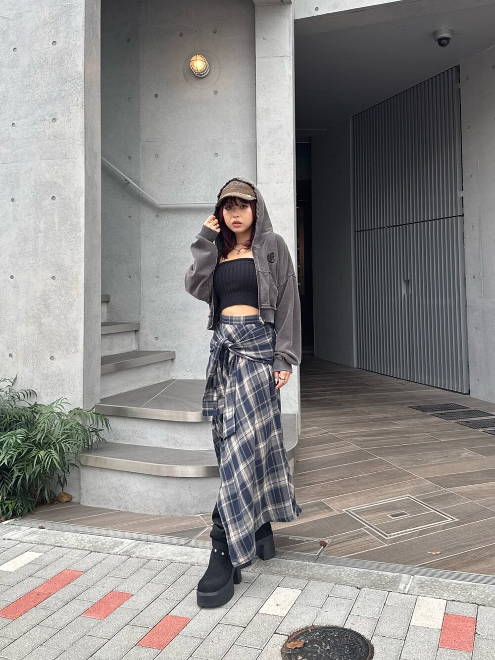 ブルー系のスカート、ブラック系のニット/セーター、ブラック系のブーツを着用したレディースの秋コーディネートの3枚目の写真