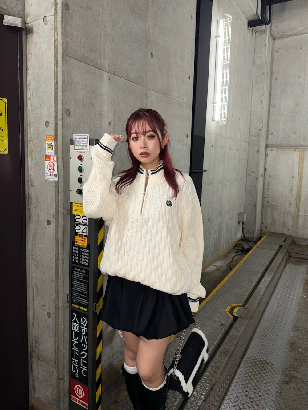 ホワイト系のニット/セーター、ブラック系のスカート、ブラック系のブーツを着用したレディースの夏コーディネートの2枚目の写真