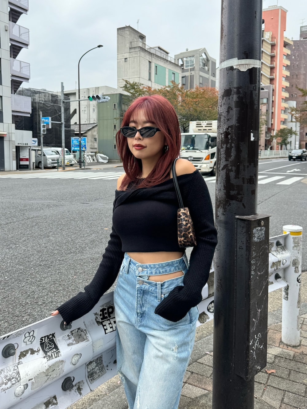 ブルー系のデニムパンツ、ブラック系のニット/セーター、レッド系のスニーカーを着用したレディースの冬コーディネートの5枚目の写真