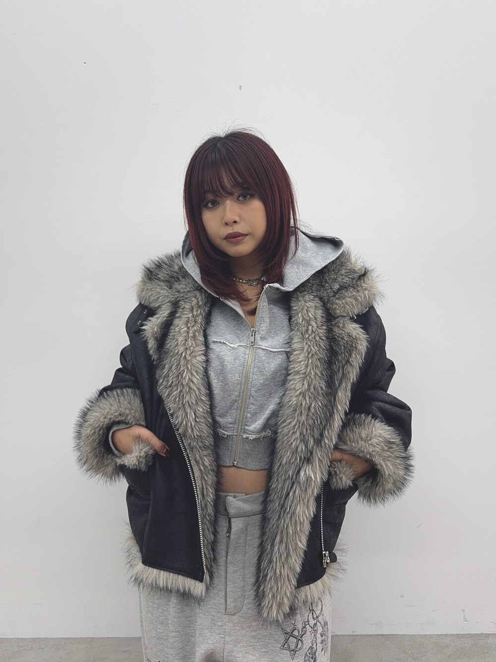 グレー系のパーカー、ブラック系のブルゾン、グレー系のスウェットパンツを着用したレディースの秋コーディネートの4枚目の写真