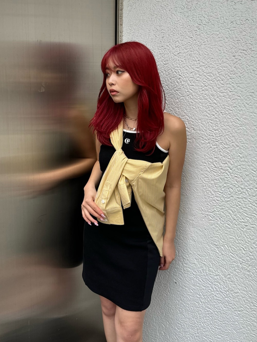 イエロー系のシャツ/ブラウス、ブラック系のワンピース、ブラック系のブーツを着用したレディースの春コーディネートの3枚目の写真