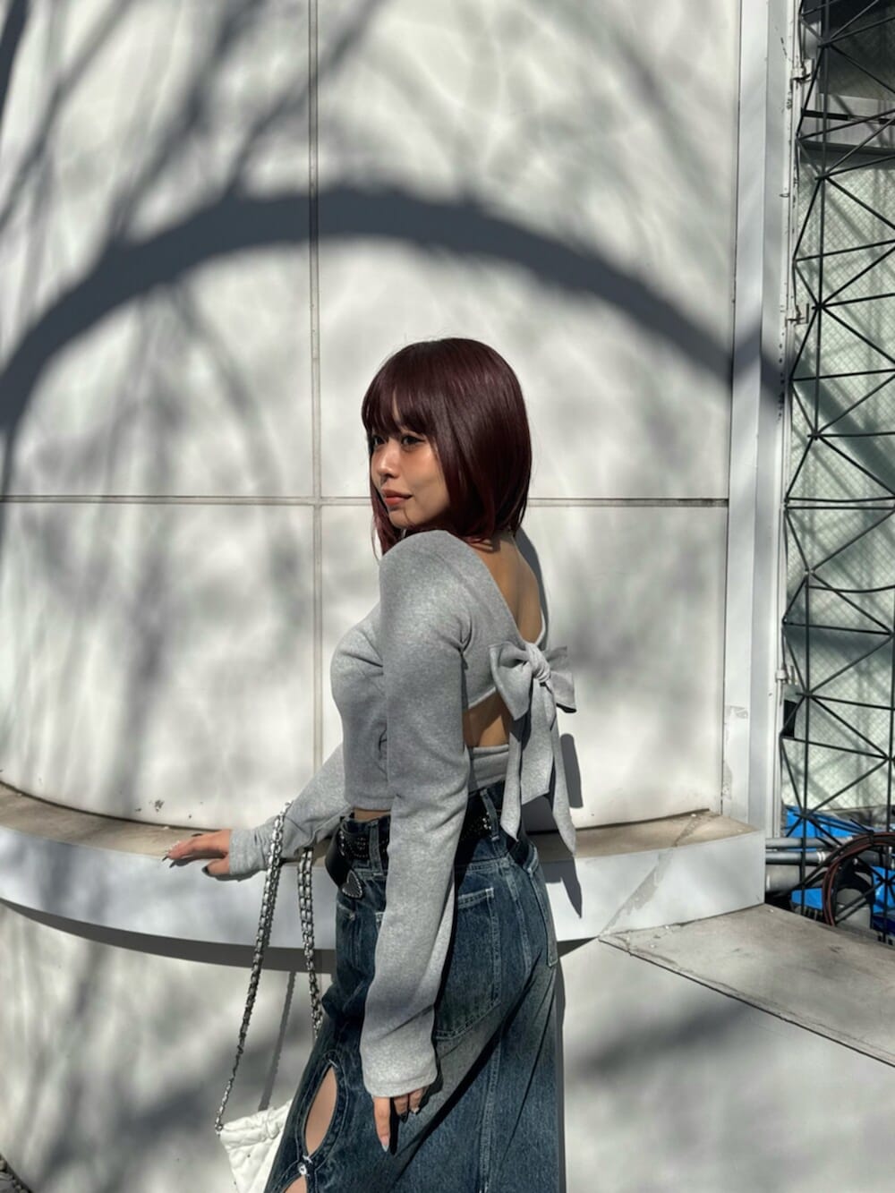 シルバー系のパンプス、ブルー系のデニムスカート、グレー系のTシャツ/カットソーを着用したレディースの春コーディネートの4枚目の写真