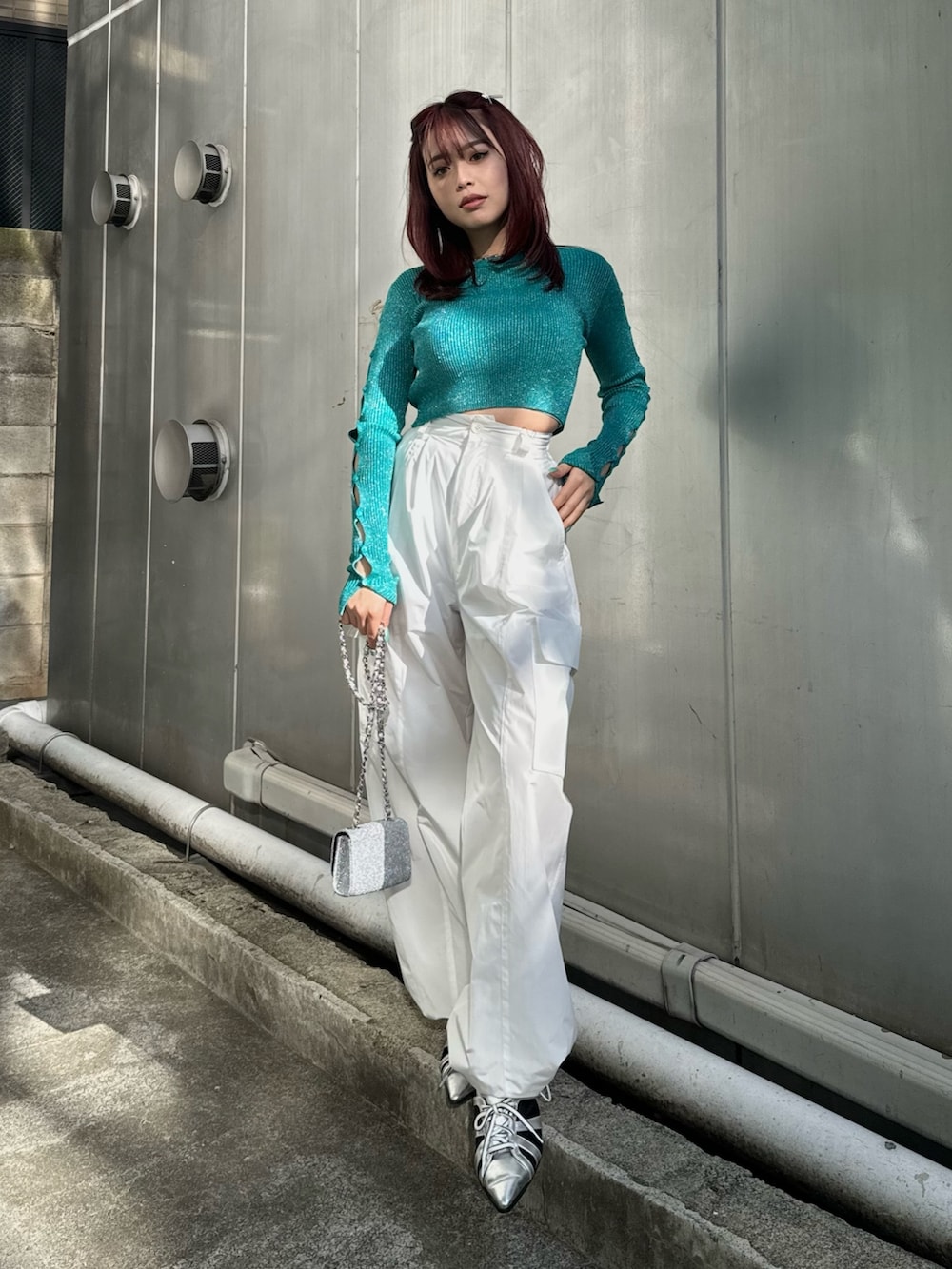 グリーン系のニット/セーター、ホワイト系のその他パンツ、シルバー系のサンダルを着用したレディースの冬コーディネートの2枚目の写真