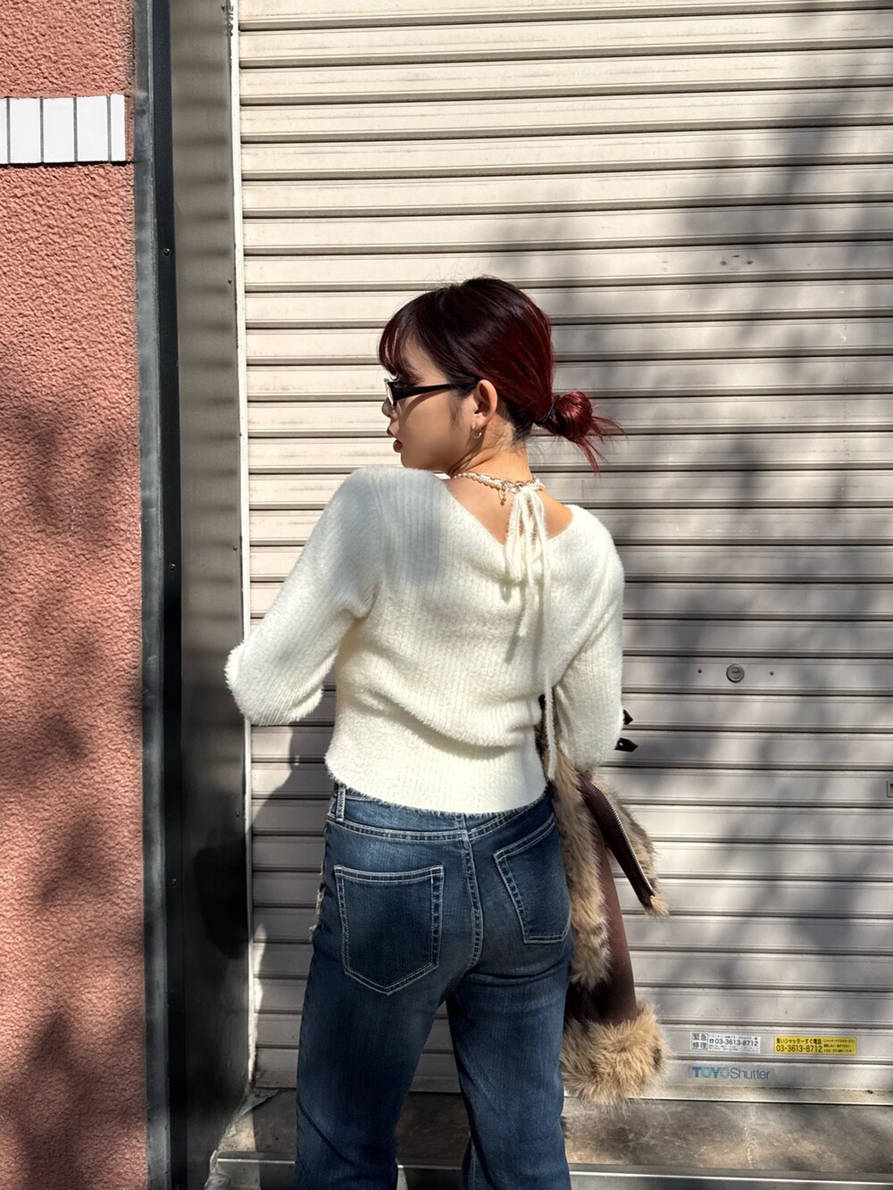 ホワイト系のニット/セーター、ブルー系のデニムパンツ、ベージュ系のスリッポンを着用したレディースの秋コーディネートの6枚目の写真