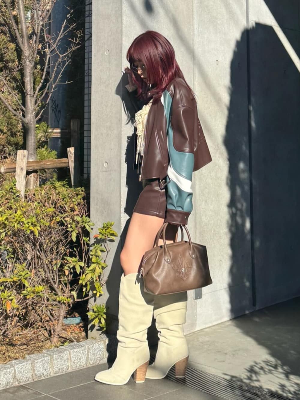 ベージュ系のシャツ/ブラウス、ブラウン系のボストンバッグ、ホワイト系のブーツを着用したレディースの冬コーディネートの3枚目の写真