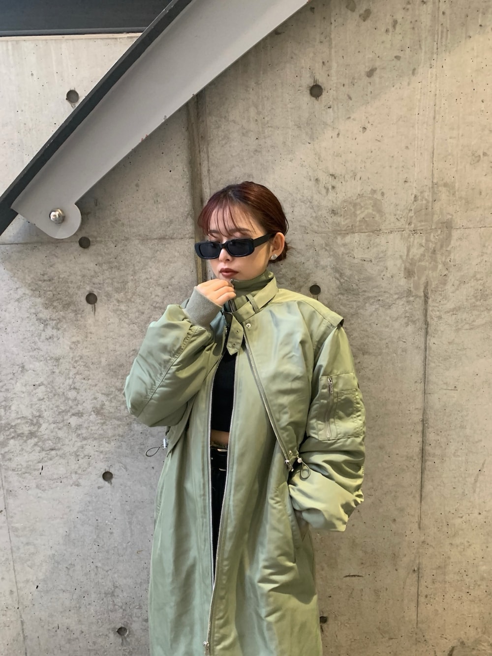 グリーン系のMA-1、ブルー系のデニムパンツ、ブラック系のスリッポンを着用したレディースの冬コーディネートの3枚目の写真