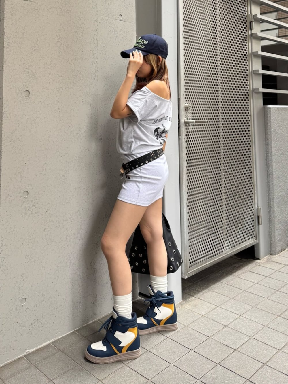ブルー系のスニーカー、グレー系のワンピース、ブラック系のベルトを着用したレディースの夏コーディネートの2枚目の写真