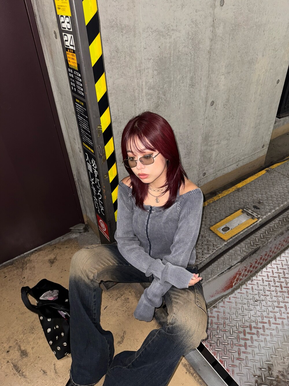 ブルー系のニット/セーター、ブルー系のデニムパンツ、ブラック系のパンプスを着用したレディースの夏コーディネートの4枚目の写真