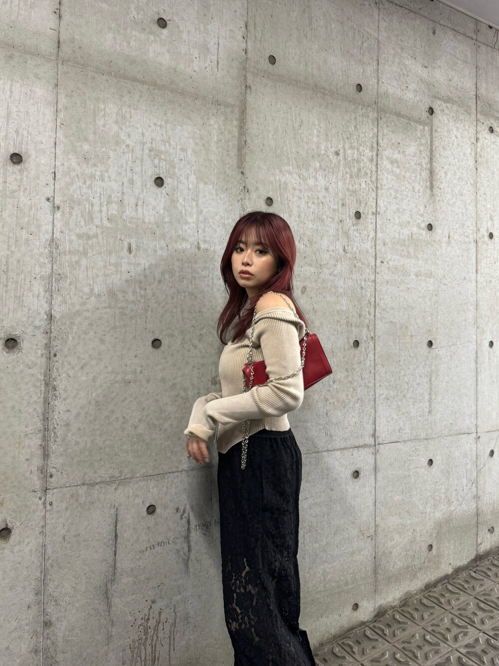 ベージュ系のニット/セーター、ブラック系のその他パンツ、レッド系のショルダーバッグを着用したレディースの夏コーディネートの4枚目の写真