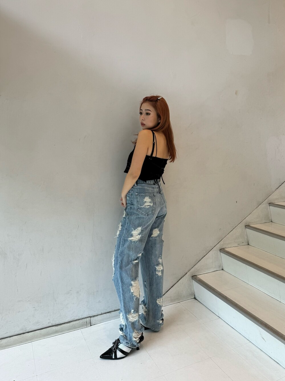 ブラック系のキャミソール、ブラック系のキャミソール、ブルー系のデニムパンツを着用したレディースの春コーディネートの2枚目の写真