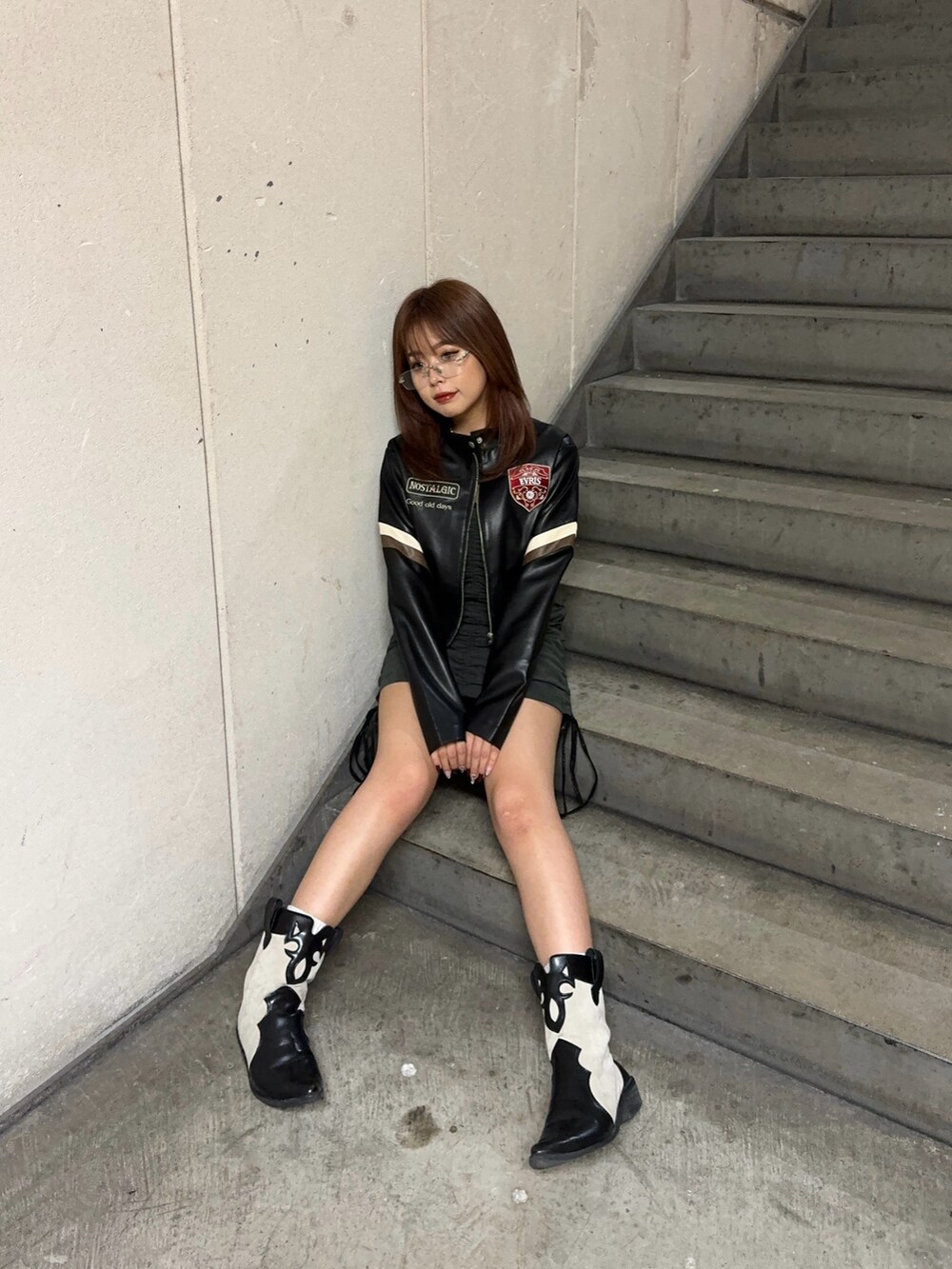 ブラック系のライダースジャケット、ブラック系のワンピースを着用したレディースの秋コーディネートの3枚目の写真