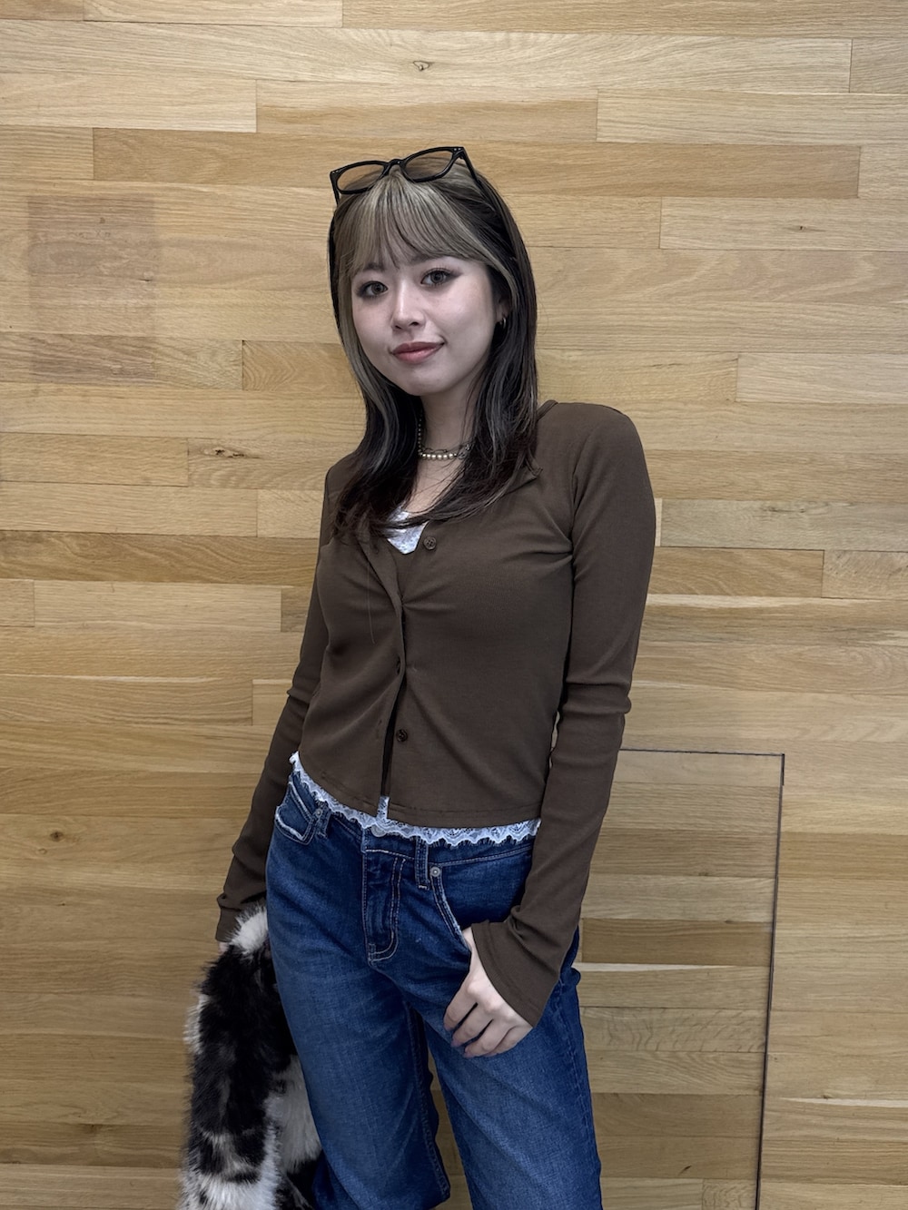 ブラウン系のTシャツ/カットソー、ブルー系のデニムパンツ、ブラウン系のブーツを着用したレディースの秋コーディネートの4枚目の写真