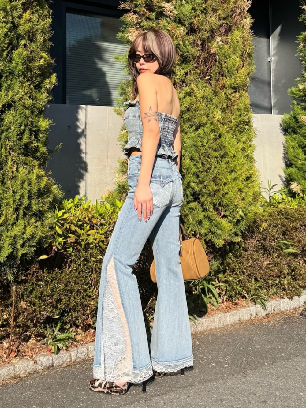 ブルー系のその他トップス、ブルー系のデニムパンツ、ブラウン系のボストンバッグを着用したレディースの春コーディネートの3枚目の写真
