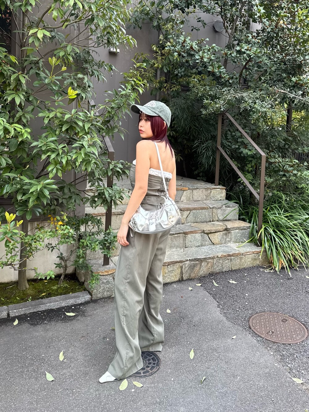 グリーン系のつなぎ/オールインワン、ホワイト系のパンプス、グリーン系のキャップを着用したレディースの春コーディネートの2枚目の写真