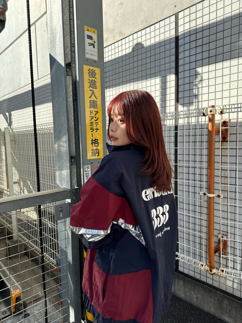 ブルー系のナイロンジャケット、グレー系のTシャツ/カットソー、シルバー系のショルダーバッグを着用したレディースの冬コーディネートの3枚目の写真