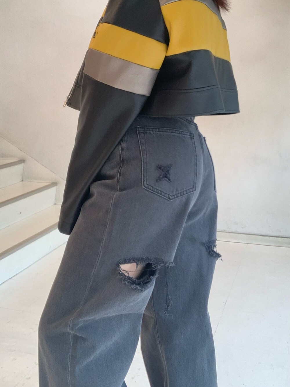 ブラック系のブルゾン、グレー系のTシャツ/カットソー、ブラック系のデニムパンツを着用したレディースの秋コーディネートの7枚目の写真