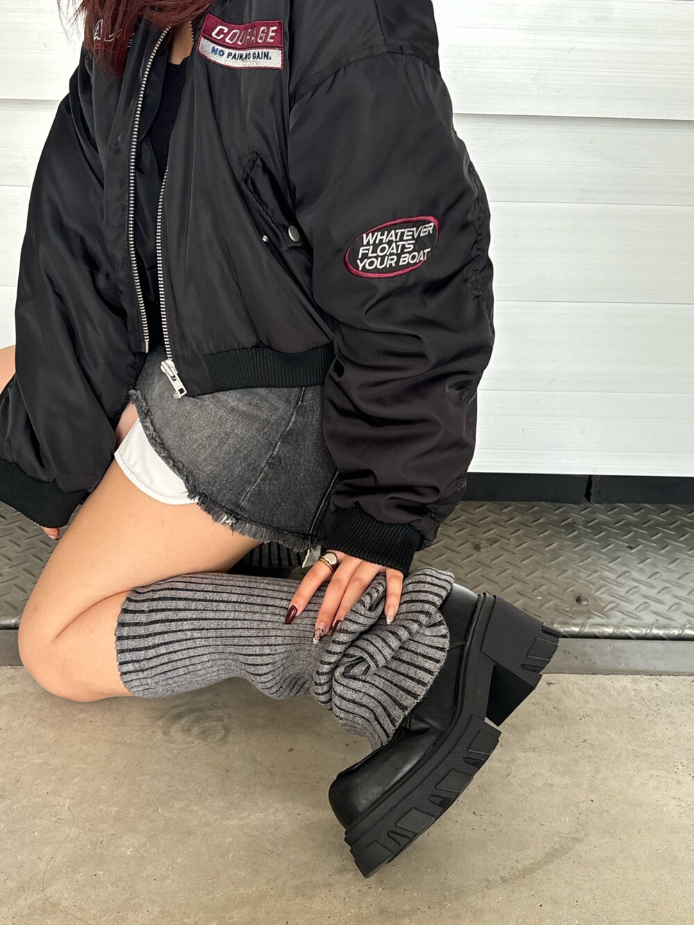 ブラック系のブルゾン、ブラック系のデニムスカート、ブラック系のローファーを着用したレディースの秋コーディネートの3枚目の写真