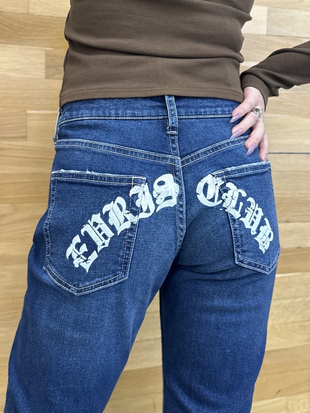 ブラウン系のTシャツ/カットソー、ブルー系のデニムパンツ、ブラウン系のブーツを着用したレディースの秋コーディネートの5枚目の写真