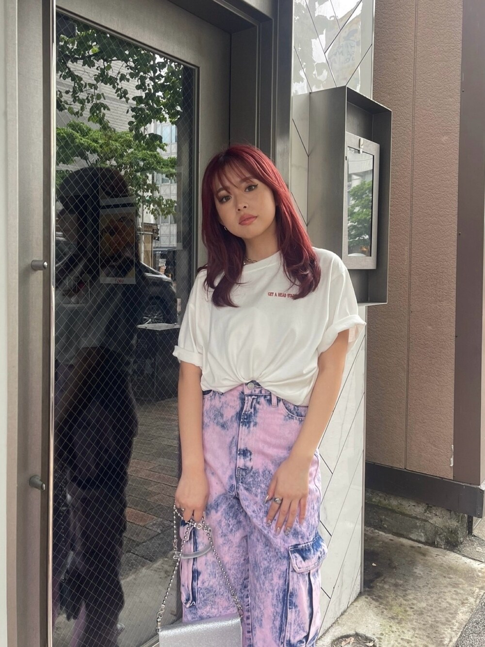 ホワイト系のTシャツ/カットソー、ブラック系のデニムパンツ、シルバー系のショルダーバッグを着用したレディースの春コーディネートの3枚目の写真