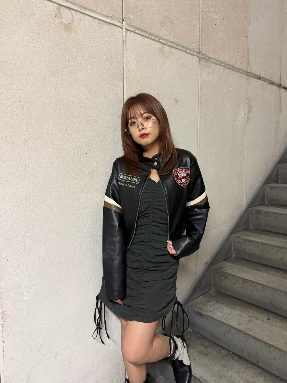 ブラック系のライダースジャケット、ブラック系のワンピースを着用したレディースの秋コーディネートの2枚目の写真