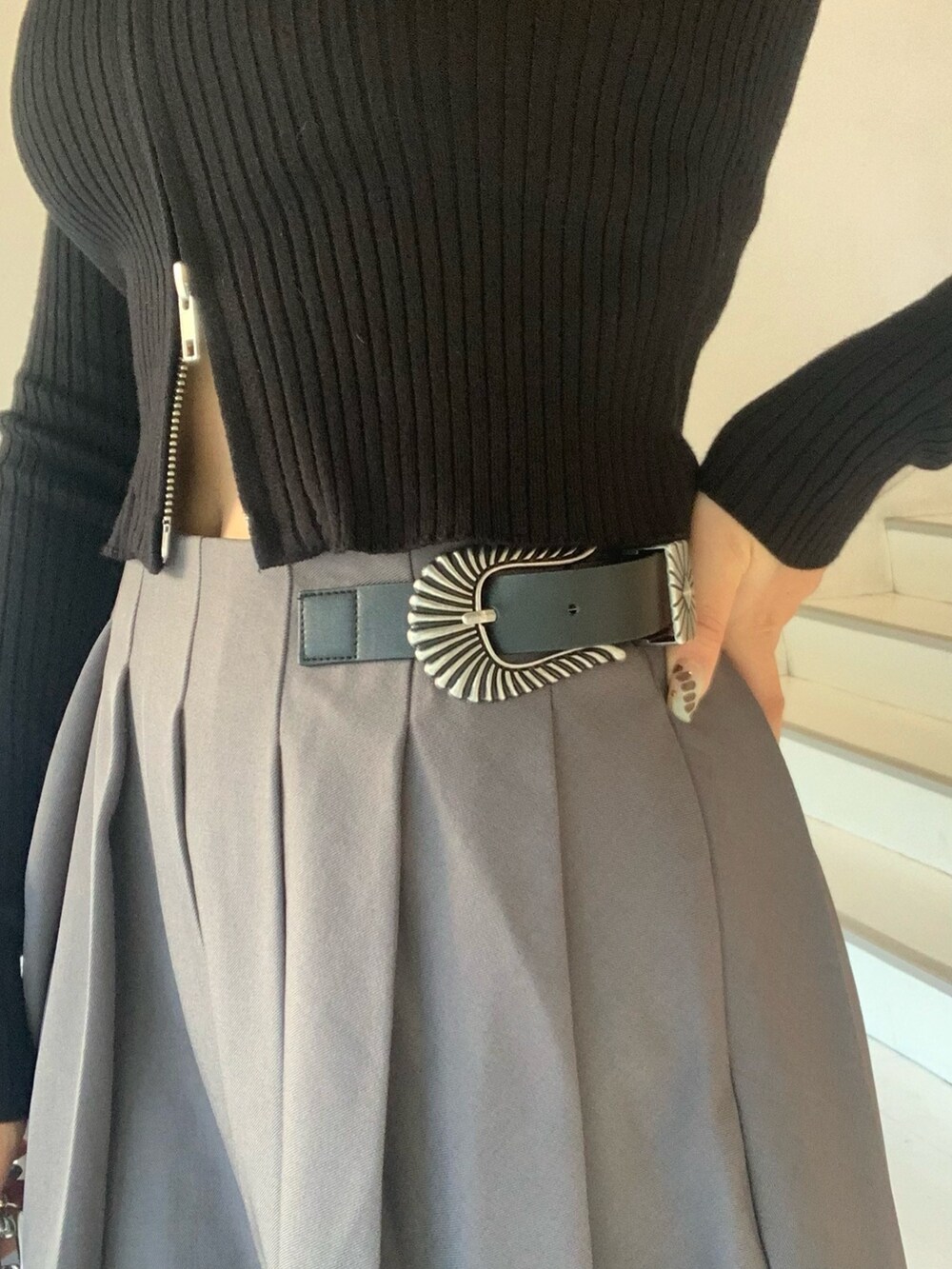 ブラック系のニット/セーター、グレー系のスカート、ブラック系のブーツを着用したレディースの秋コーディネートの5枚目の写真