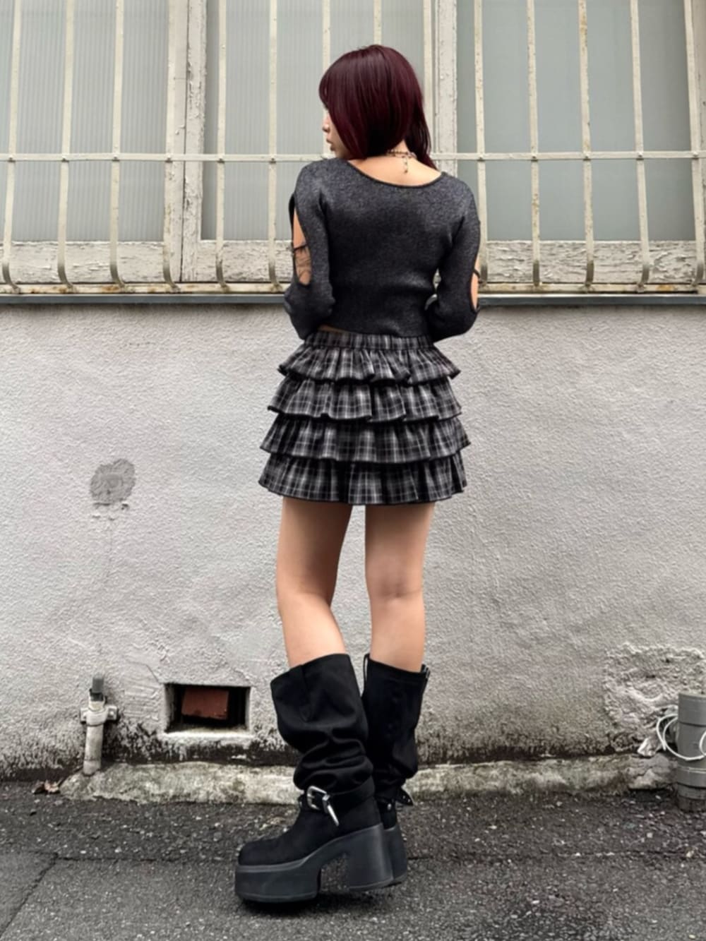 ブラック系のブーツ、ブラック系のスカート、ブラック系のニット/セーターを着用したレディースの秋コーディネートの3枚目の写真