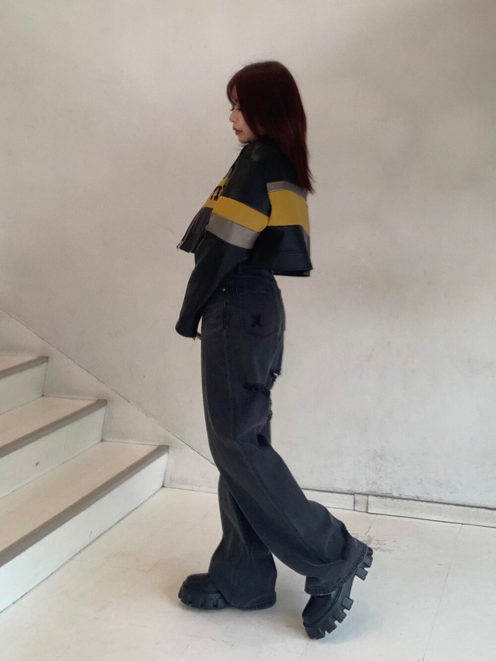 ブラック系のブルゾン、グレー系のTシャツ/カットソー、ブラック系のデニムパンツを着用したレディースの秋コーディネートの2枚目の写真