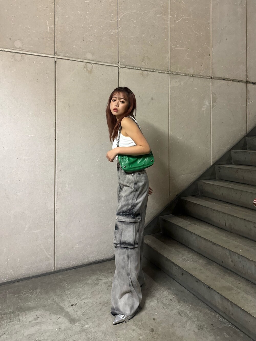 ホワイト系のタンクトップ、ブラック系のデニムパンツを着用したレディースの夏コーディネートの3枚目の写真