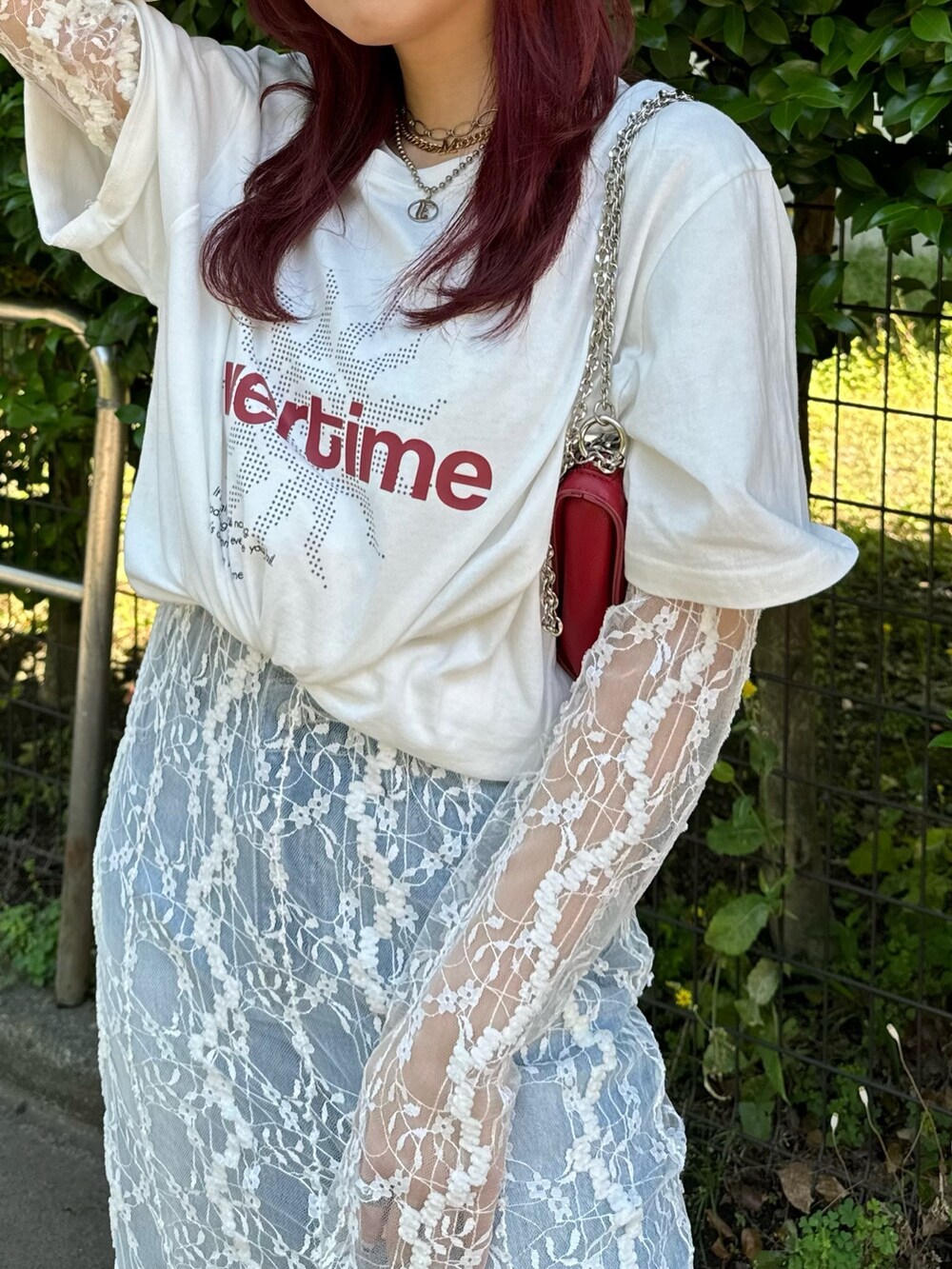 ホワイト系のワンピース、ブルー系のデニムパンツ、レッド系のサンダルを着用したレディースの夏コーディネートの3枚目の写真