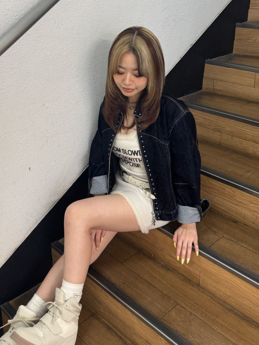 ブルー系のデニムジャケット、ホワイト系のワンピース、ホワイト系のスニーカーを着用したレディースの夏コーディネートの4枚目の写真