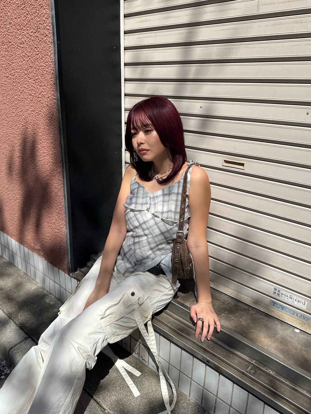 イエロー系のキャミソール、ホワイト系のカーゴパンツ、ホワイト系のパンプスを着用したレディースの春コーディネートの3枚目の写真