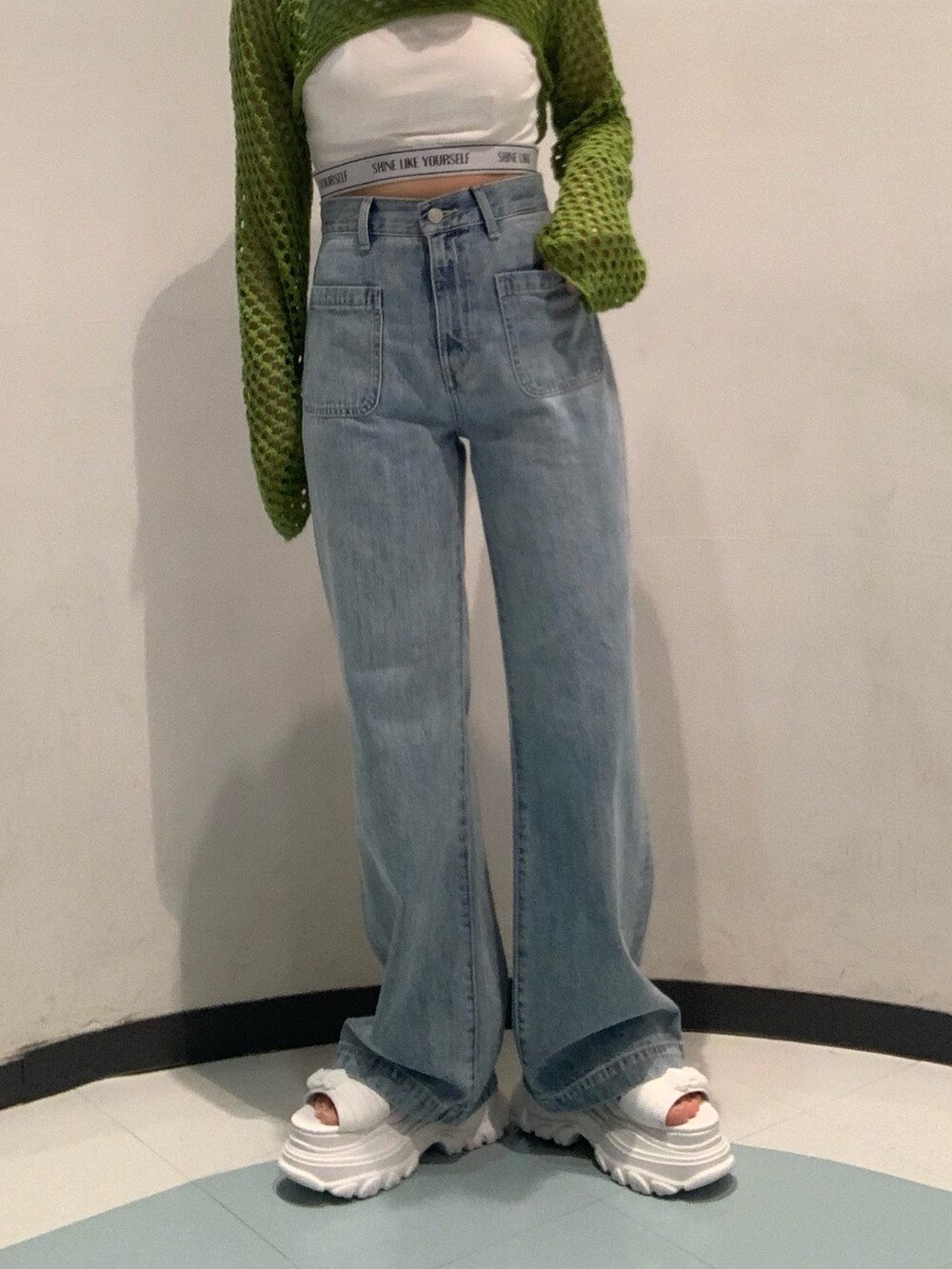 ホワイト系のサンダル、ブルー系のデニムパンツ、ホワイト系のキャミソールを着用したレディースの春コーディネートの6枚目の写真