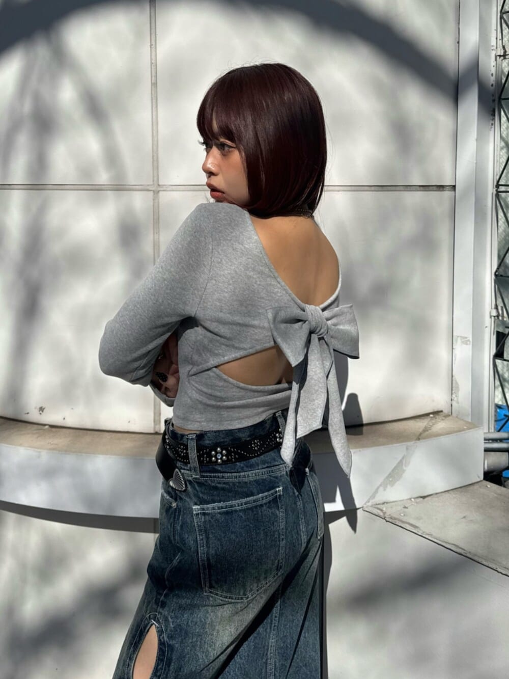 シルバー系のパンプス、ブルー系のデニムスカート、グレー系のTシャツ/カットソーを着用したレディースの春コーディネートの5枚目の写真