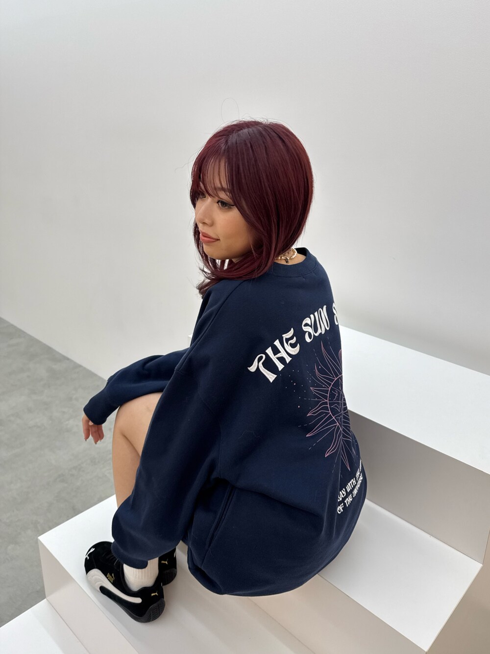 ブルー系のスウェット、ブラック系のスニーカーを着用したレディースの冬コーディネートの3枚目の写真