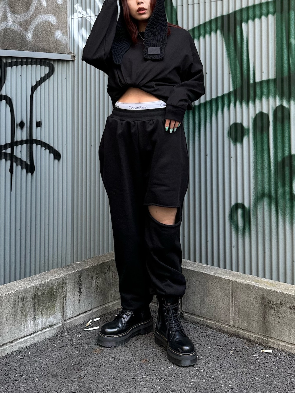 ブラック系のTシャツ/カットソー、ブラック系のスウェットパンツ、ブラック系のブーツを着用したレディースの冬コーディネートの2枚目の写真