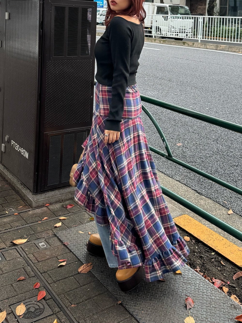 ブラック系のニット/セーター、ブルー系のスカート、ブルー系のデニムパンツを着用したレディースの秋コーディネートの2枚目の写真