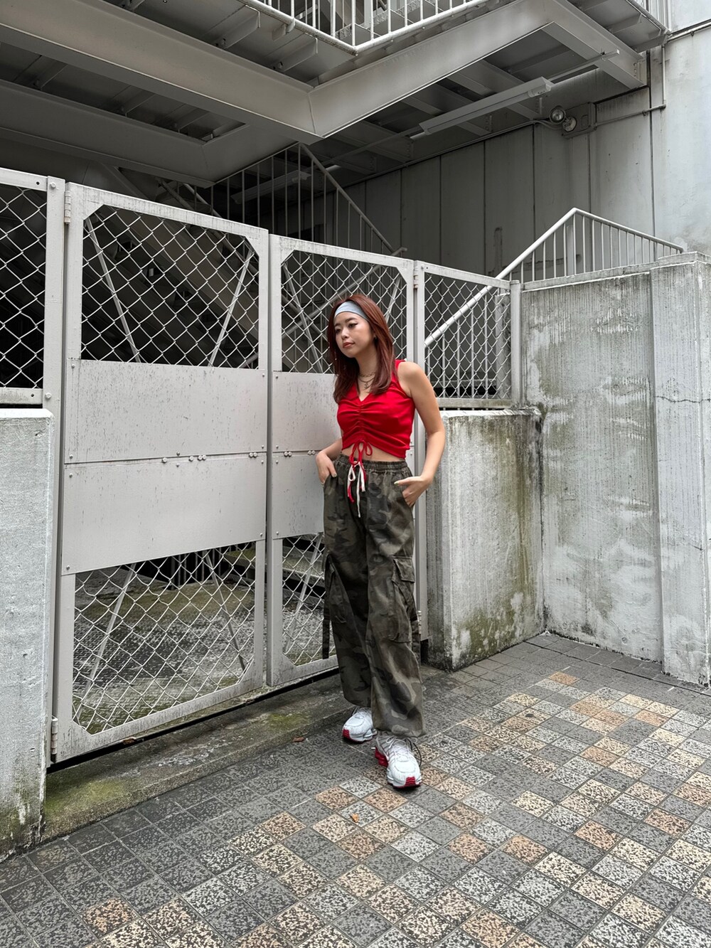 レッド系のタンクトップを着用したレディースの夏コーディネートの3枚目の写真