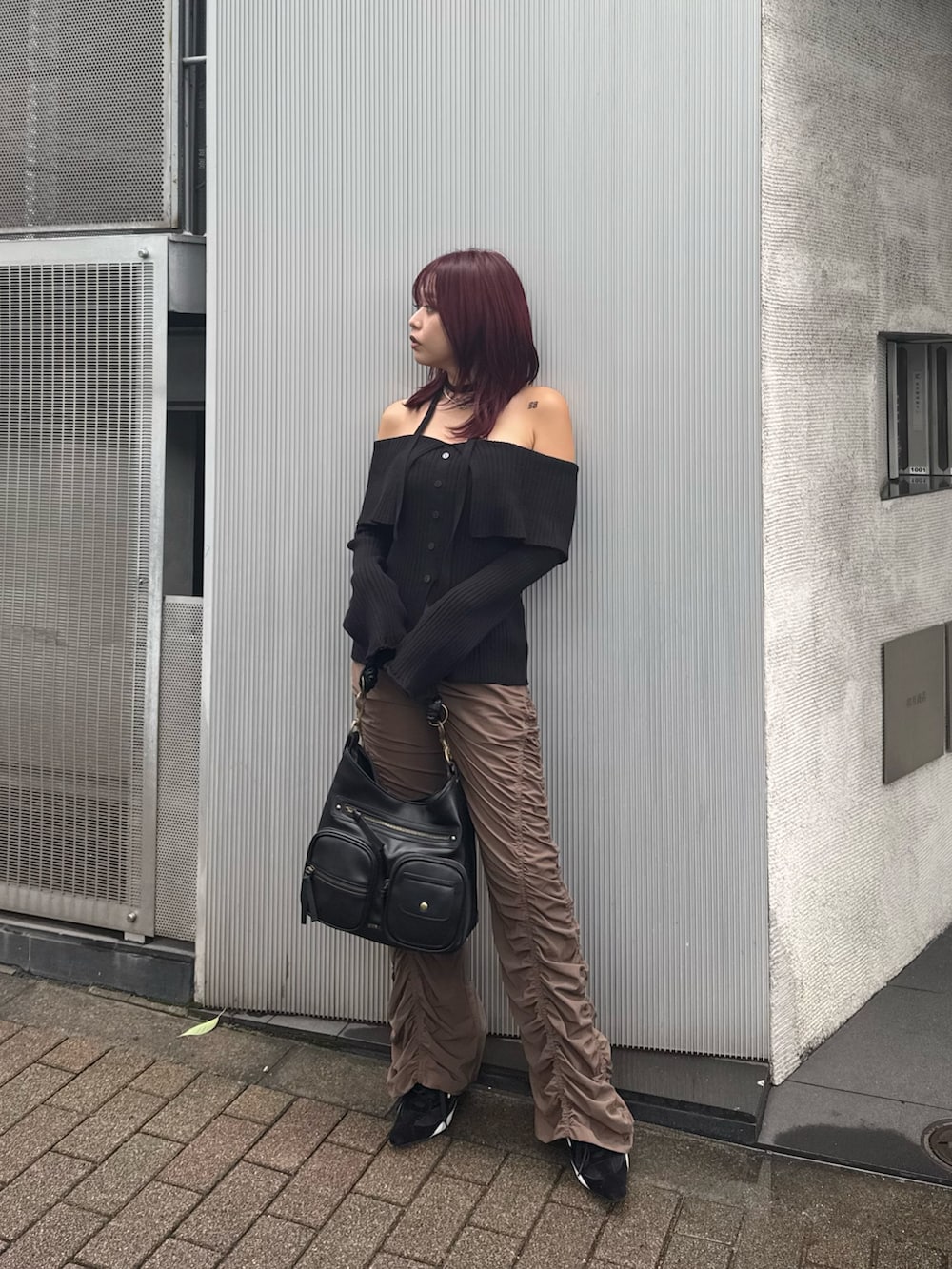 ブラック系のニット/セーター、ブラウン系のその他パンツ、ブラック系のハンドバッグを着用したレディースの夏コーディネートの3枚目の写真