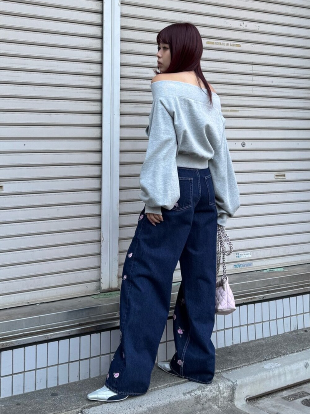 シルバー系のパンプス、グレー系のスウェット、ピンク系のショルダーバッグを着用したレディースの冬コーディネートの2枚目の写真