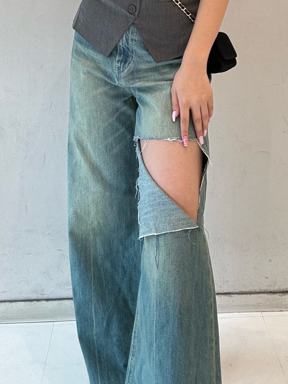 グレー系のキャミソール、ブラック系のブーツ、ブラック系のショルダーバッグを着用したレディースの春コーディネートの4枚目の写真