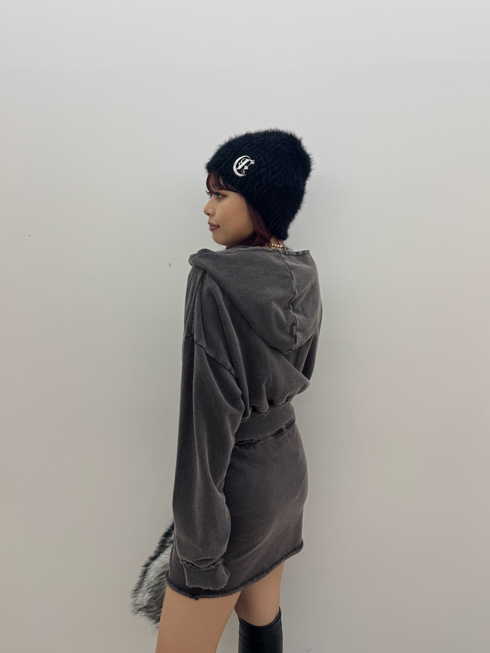 ブラック系のパーカー、ブラック系のスカート、ブラック系のボストンバッグを着用したレディースの秋コーディネートの6枚目の写真